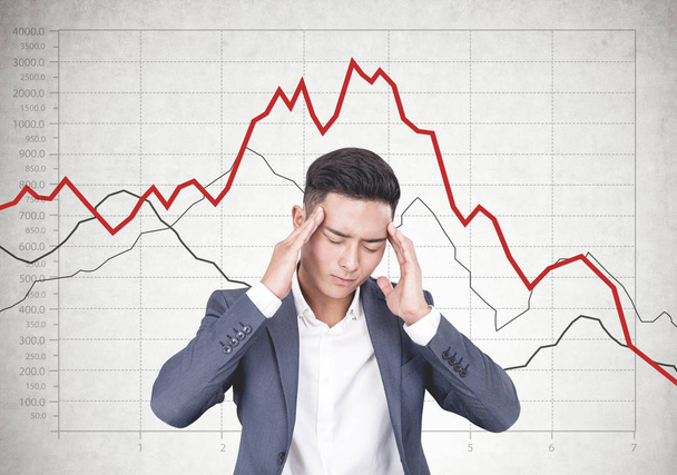 Stressed Asian businessman, falling graph - Fotó, kép