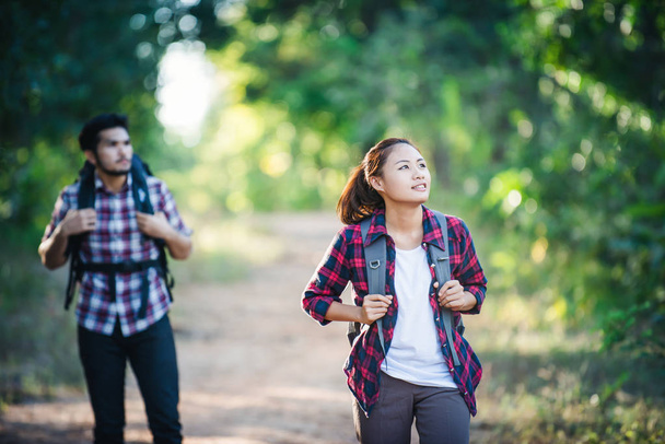 Jeune couple marchant avec des sacs à dos en forêt. Randonnées aventure
,  - Photo, image