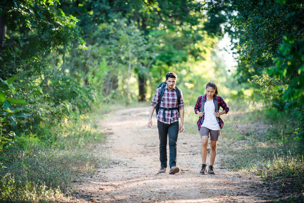 Young couple walking with backpacks in forest. Adventure hikes,  - Photo, Image