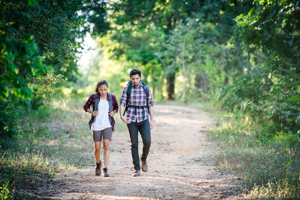 Jeune couple marchant avec des sacs à dos en forêt. Randonnées aventure
,  - Photo, image