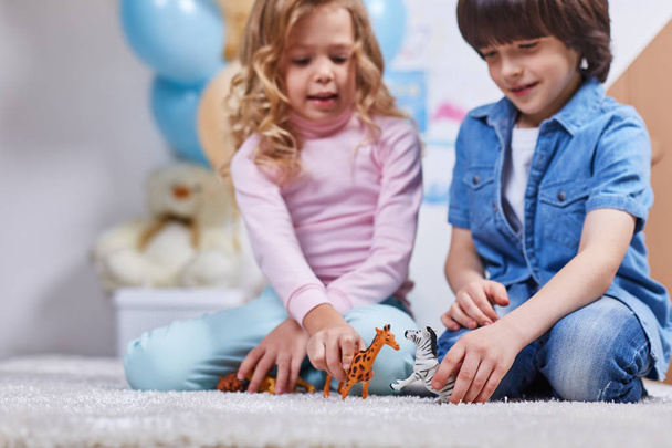Crianças alegres brincam com brinquedos no tapete
 - Foto, Imagem