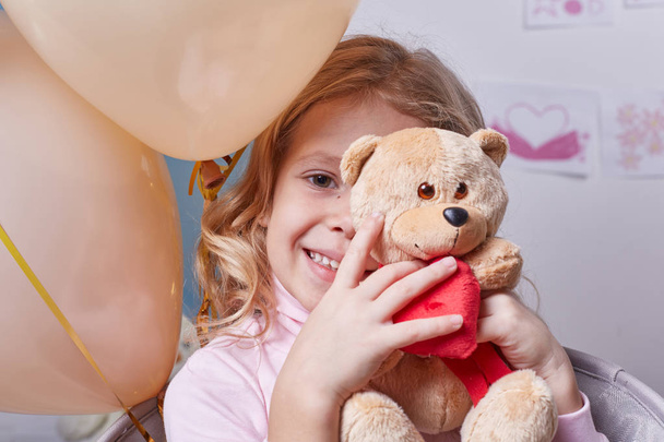 Happy girl toying with bear - Fotografie, Obrázek