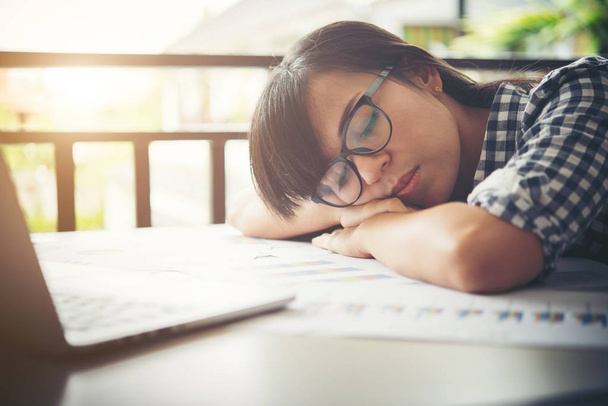 Mujer de negocios cansada dormida en un portátil mientras trabaja en su varita
 - Foto, Imagen