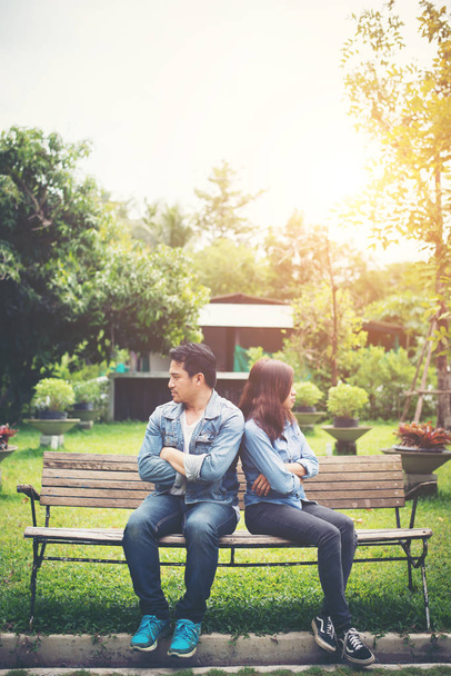 Displeased young couple sitting on bench in park, Couple lifesty - Photo, Image