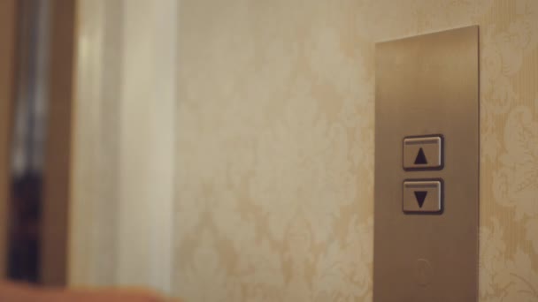 Botão de mão feminina para chamar elevador no corredor do apartamento
 - Filmagem, Vídeo