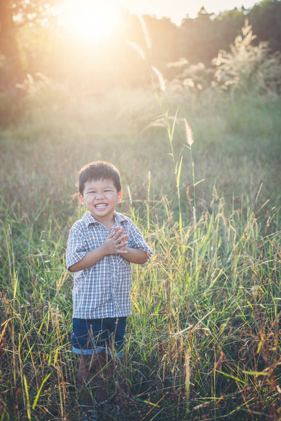 Szczęśliwy mały chłopiec azjatyckich, bawiąc się na zewnątrz. Cieszyć się życiem. Ładna Azjatka  - Zdjęcie, obraz