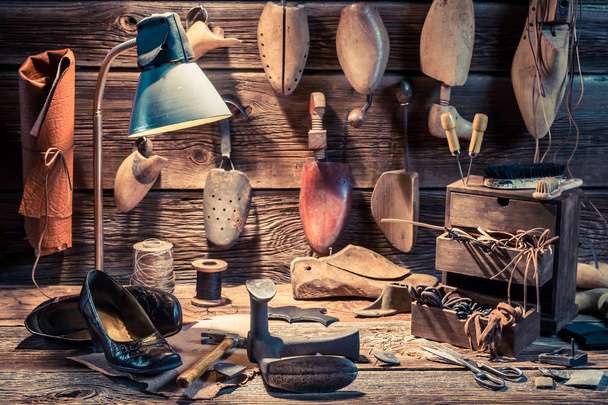Shoemaker workplace with shoes, tools and laces - Foto, imagen