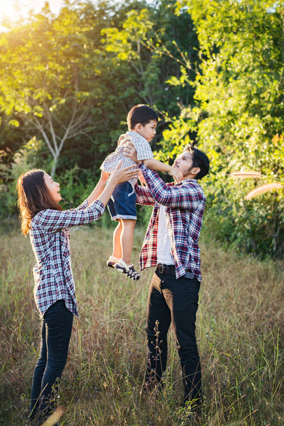 Щаслива молода сім'я проводить час разом надворі у зеленій природі
 - Фото, зображення