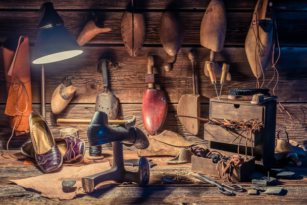 Κοντινό πλάνο του τσαγκάρη εργαστηρίου με εργαλεία, δερμάτινα και παπούτσια - Φωτογραφία, εικόνα