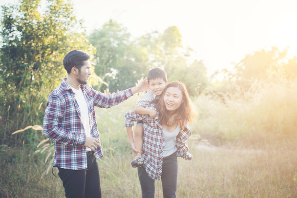 Joyeux jeune famille passer du temps ensemble dehors dans la nature verte
 - Photo, image