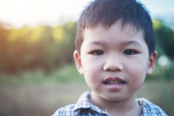 Close up of cute asian boy playing and smiling outdoors. Cute li - Фото, зображення