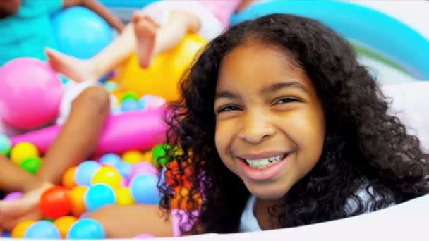 Kleine lachende Mädchen spielen Plastikbälle - Filmmaterial, Video