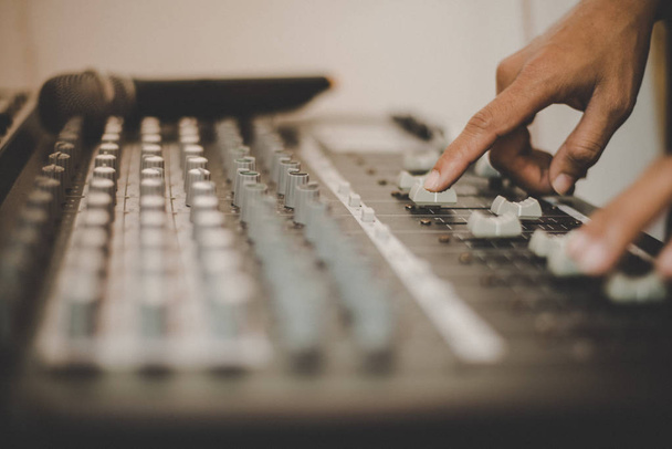Man hands of sound engineer adjusting audio mixing console. - Photo, Image