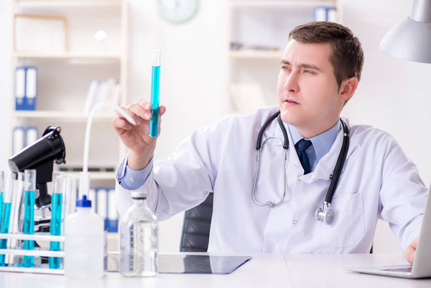Чоловік лікар дивиться на лабораторні результати в лікарні
 - Фото, зображення