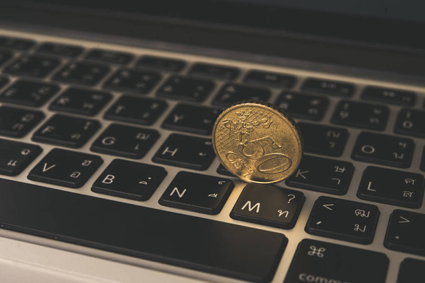 Golden coin on laptop keyboard. - Photo, image