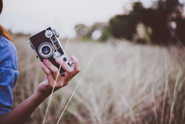 Happy young hipster woman with vintage camera in field. Enjoy wi - Φωτογραφία, εικόνα