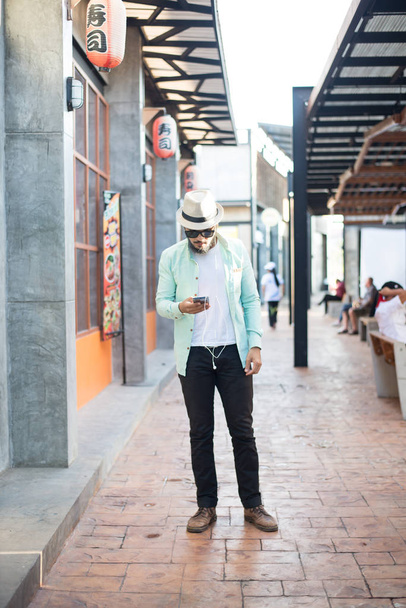 Hipster man listening music with his smartphone on the street in - Photo, image