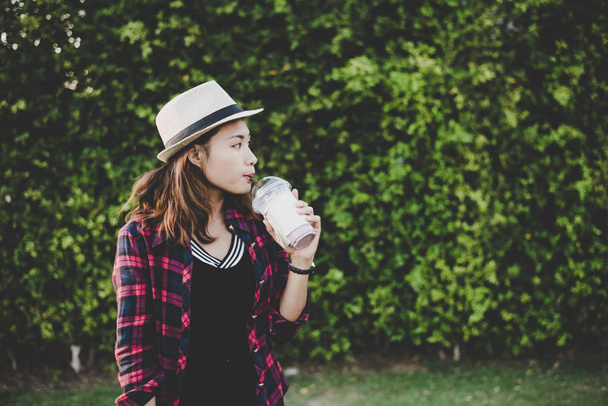 schöne Hipster-Frau, die Milchshake trinkt, steht in der Nähe von grünen T - Foto, Bild