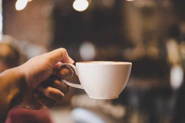 Bir fincan kahve kafede vintage filtresiyle holding eller. - Fotoğraf, Görsel