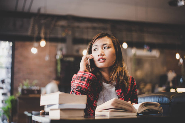 Jeune femme hipster parler au téléphone tout en lisant un livre à caf
 - Photo, image