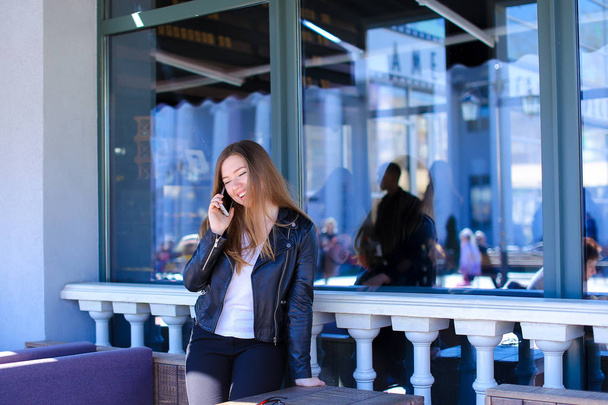 Jongere praten door smartphone op straat café. - Foto, afbeelding