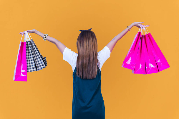 Docela hezká móda dívka s nákupní taškou barevné oranžové pozadí - Fotografie, Obrázek