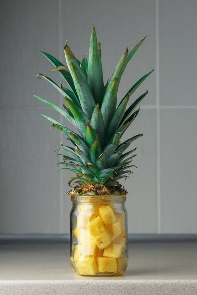 Fresh juicy pineapple pieces in a glass jar - Фото, изображение