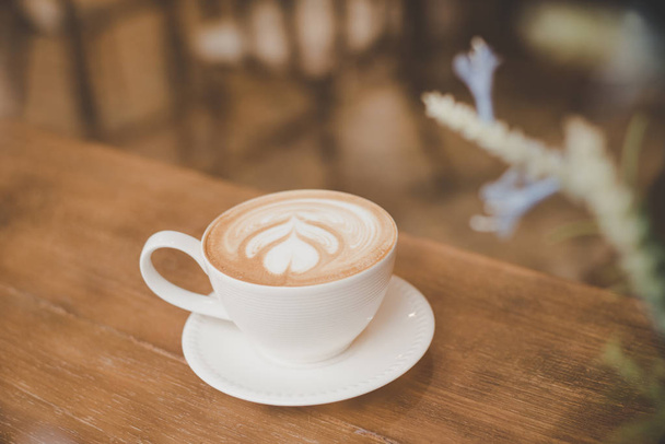 Couleur vintage ton de café latte art sur une table en bois dans un café
. - Photo, image