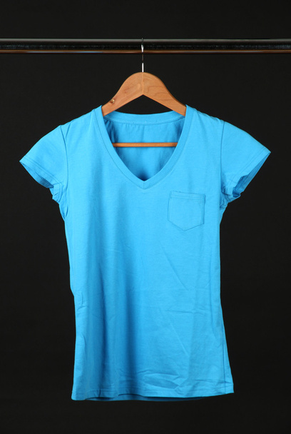 T-shirt on wooden hanger, isolated on black - Foto, immagini