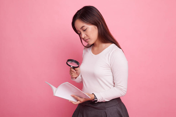 Asian woman with a book and magnifying glass. - Foto, imagen