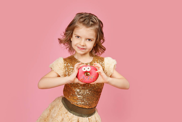 Little girl in dress with donuts - Fotó, kép