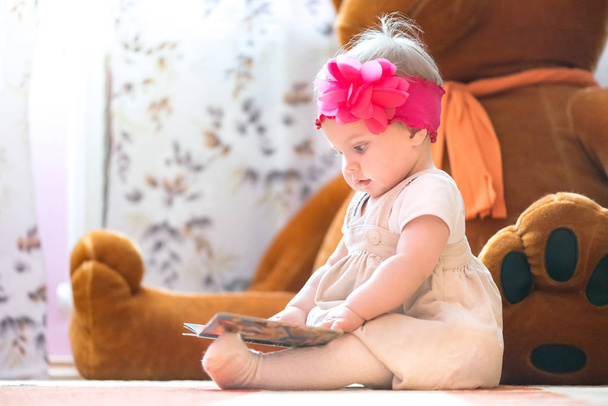10 aylık bebek kız bir kitap incelenmesi - Fotoğraf, Görsel