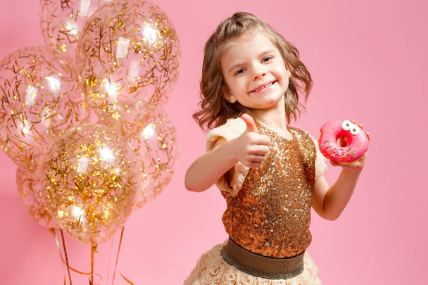 Chica sosteniendo donut y gesto pulgar hacia arriba
 - Foto, Imagen