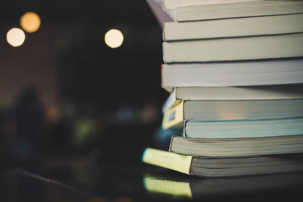 piles of books on table over blurred library background. - Photo, Image