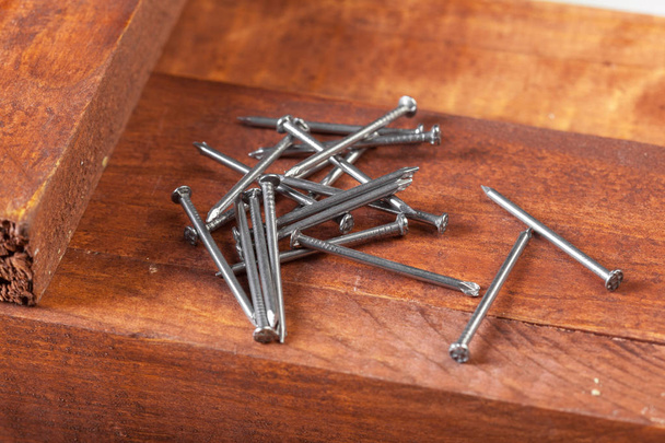 Pile of iron nails on wooden table - Φωτογραφία, εικόνα