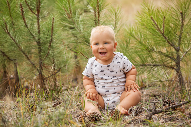Portrait of a baby boy in green pine forest - 写真・画像