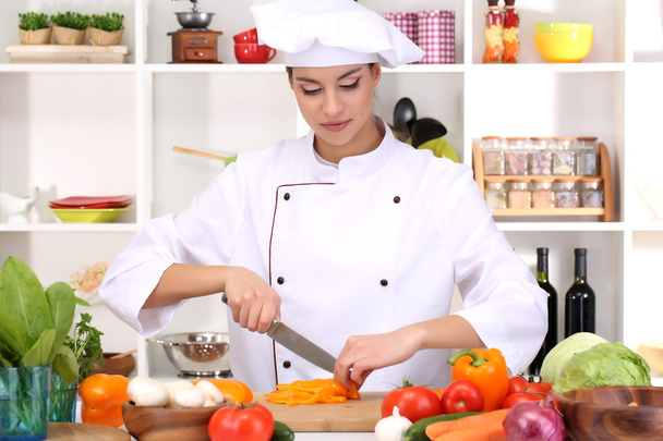 Young woman chef cooking in kitchen - Foto, imagen