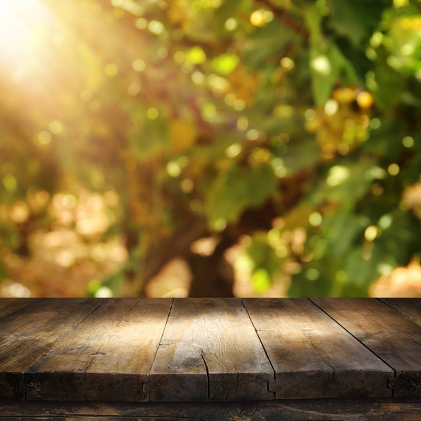 Image of wooden table in front of blurred vineyard landscape. Ready for product display montage. - Valokuva, kuva