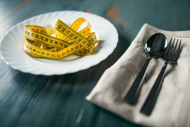 ahşap masa portre, kilo kaybı diyet kavramı kasette ölçme ile plaka - Fotoğraf, Görsel