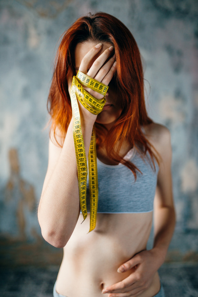 γυναίκα που καλύπτουν το πρόσωπο με το χέρι δεμένο με μεζούρα, απώλεια βάρους - Φωτογραφία, εικόνα