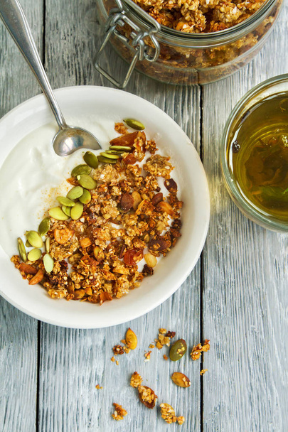 Granola Café da manhã com iogurte em um prato e chá de ervas
 - Foto, Imagem