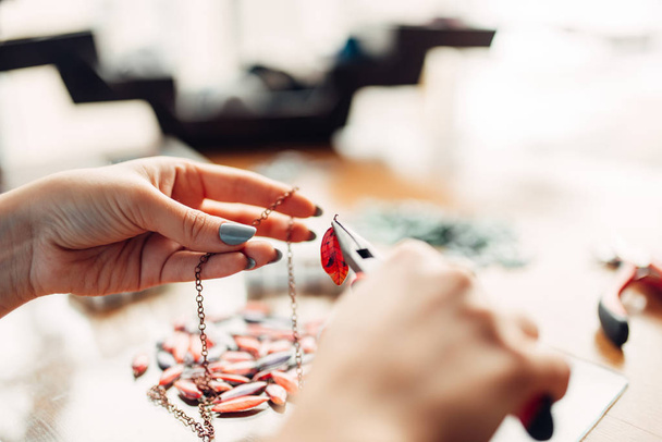 woman holding pliers, master at workplace, handmade jewelry, needlework, fashion bijouterie making - Photo, Image