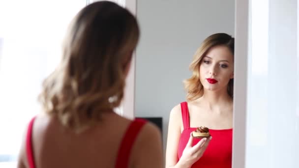 Νέοι κοκκινομάλλα γυναίκα τρώει ένα κέικ - Πλάνα, βίντεο