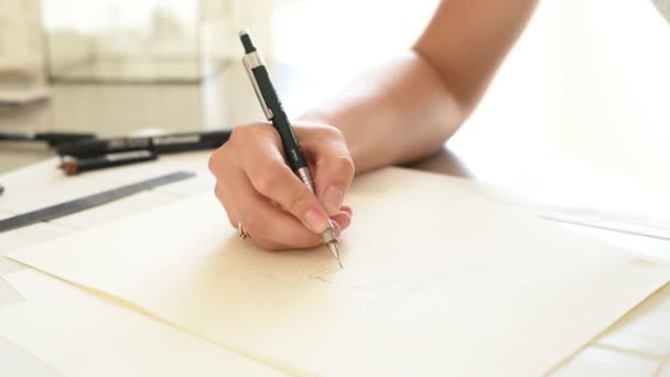 Logo Designer írás. Tervezők kéz tartja a toll és az írás a logó. Nő a tervező dolgozik a projekten dolgozó irodájába  - Felvétel, videó