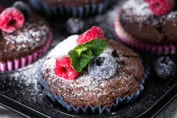Chocolate orange muffins or cupcakes with berries. - Photo, image