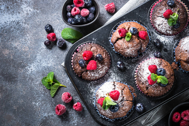 Chocolate orange muffins or cupcakes with berries. - Photo, Image