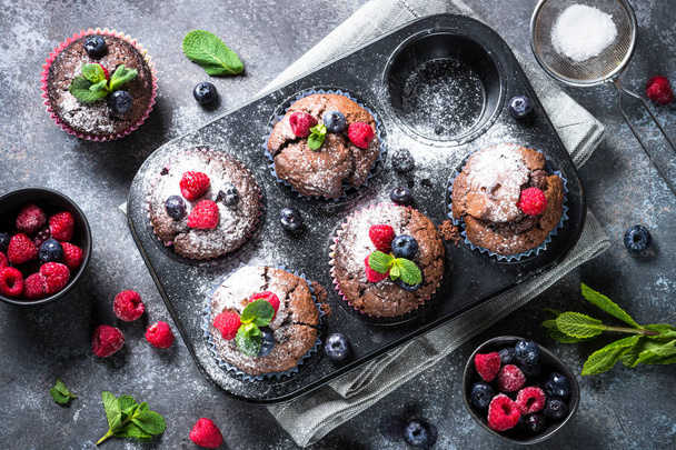 Chocolate orange muffins or cupcakes with berries. - Photo, image