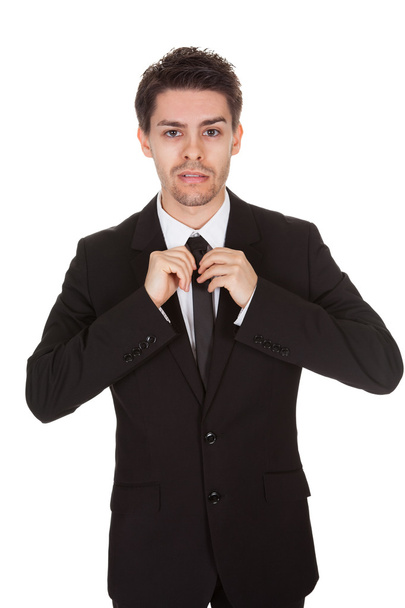 Üzletember kiegyenesítése a nyakkendőjét - Fotó, kép