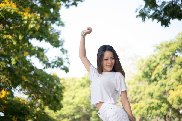 Portrait of teenage girl raising arms and laughing in the park. - Foto, Imagem