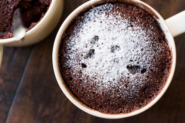 Microwave Brownie Chocolate Mug Cake with Powder Sugar on Dark Wooden Surface. - Photo, Image